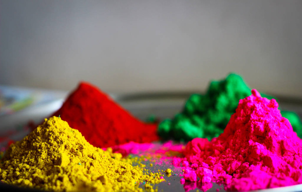 Holi φεστιβάλ πολλαπλών χρώμα σε σκόνη σε ένα πιάτο κόκκινο πράσινο κίτρινο ροζ - Φωτογραφία, εικόνα