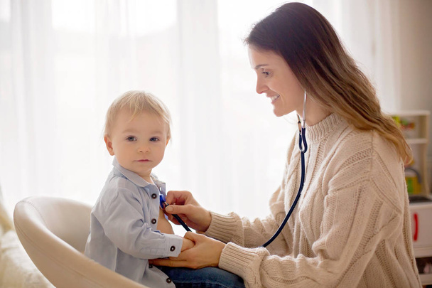 Pediatrician examining baby boy. Doctor using stethoscope for yearly child check up - Φωτογραφία, εικόνα