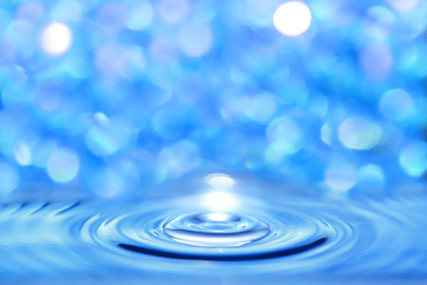Abstract Water blauwe vloeistof doorkruist door een ronde golf op een heldere bokeh-achtergrond. - Foto, afbeelding