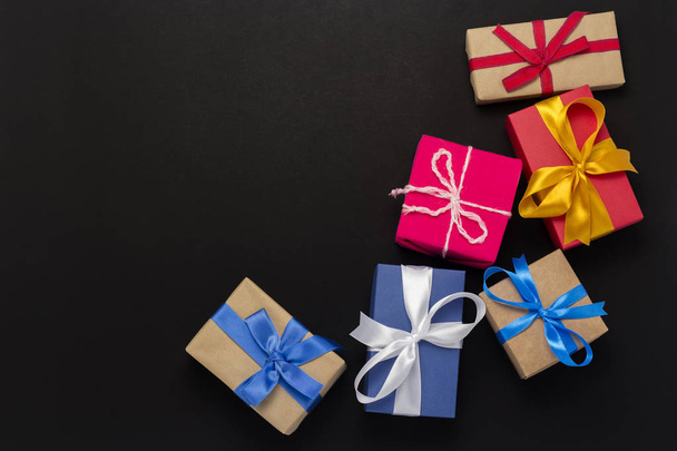A lot of gift boxes on a black background. Holiday concept, New Year, Christmas, Birthday, Valentine's Day. Copy space. Flat lay, top view - Foto, imagen