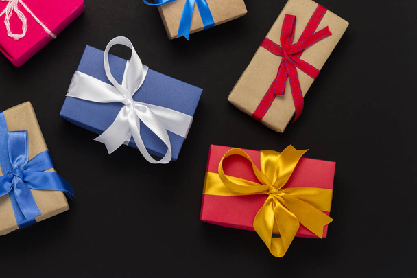 A lot of gift boxes on a black background. Holiday concept, New Year, Christmas, Birthday, Valentine's Day. Copy space. Flat lay, top view - Foto, Bild