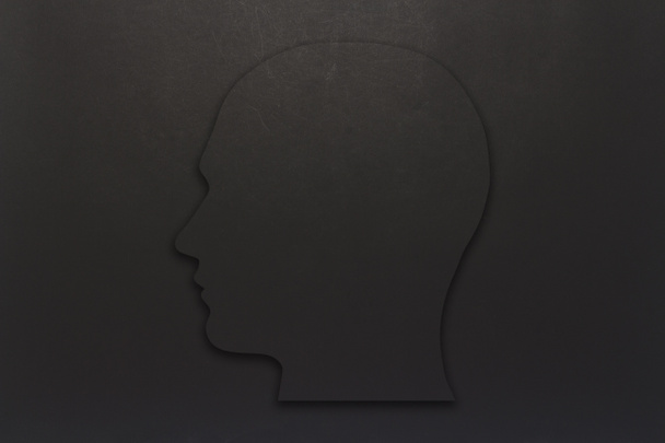Μαύρο χαρτόνι κεφάλι πάνω σε μαύρο φόντο. Αντιγράψτε το χώρο. Επίπεδη lay, κορυφαία προβολή - Φωτογραφία, εικόνα