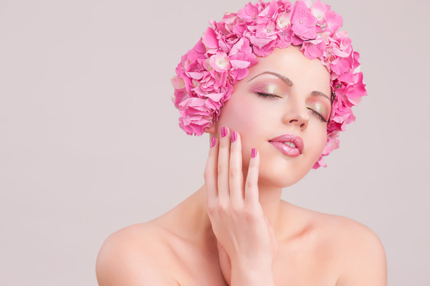 Gyönyörű nő fején rózsaszín virágokkal - Fotó, kép
