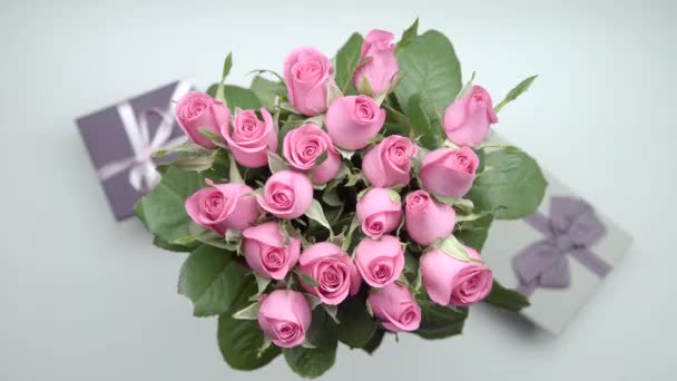 Bouquet de roses roses et deux cadeaux sur la table. Tir statique. 23 ans
 - Séquence, vidéo