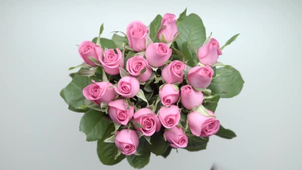 Las manos de las mujeres ponen un ramo de rosas rosadas y dos regalos sobre la mesa. 21
 - Metraje, vídeo
