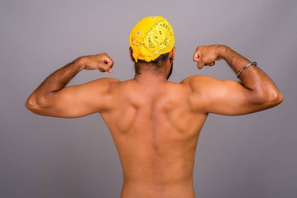 Young handsome Indian man shirtless against gray background - Photo, image