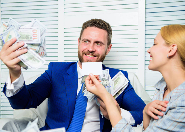 Man business owner sit office pile of money. Bank assistant offer plastic card. Create bank account. Credit loan and cash concept. Businessman with cash bank client. Office manager hold bank card - Photo, image
