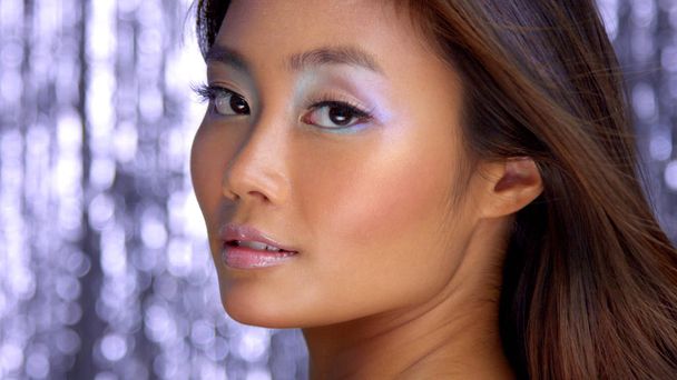 thai asian model in studio with silver rain disco background and party makeup - Photo, Image