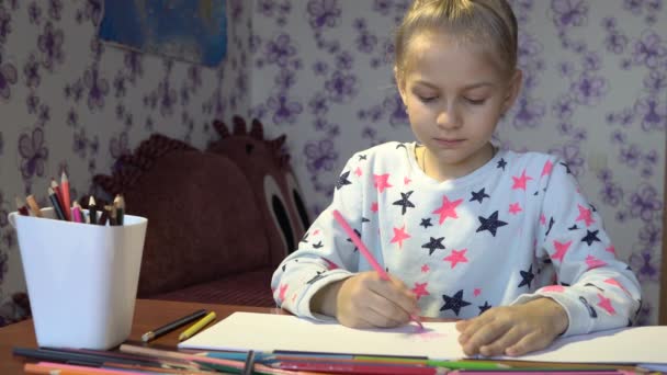 Bright cute little girl draws with crayons on white sheets - Séquence, vidéo