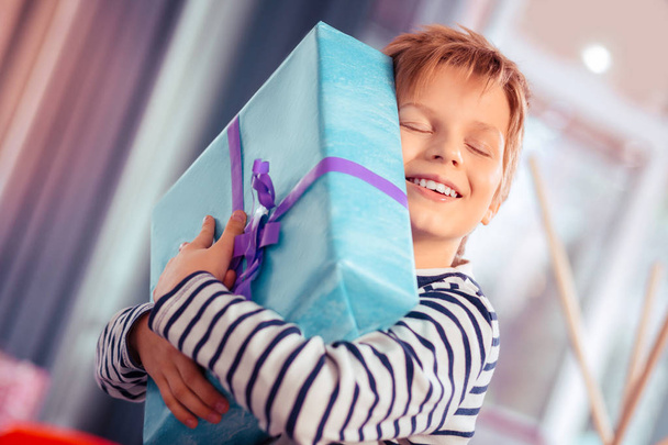 Happy birthday boy embracing his gift boxes - Photo, Image