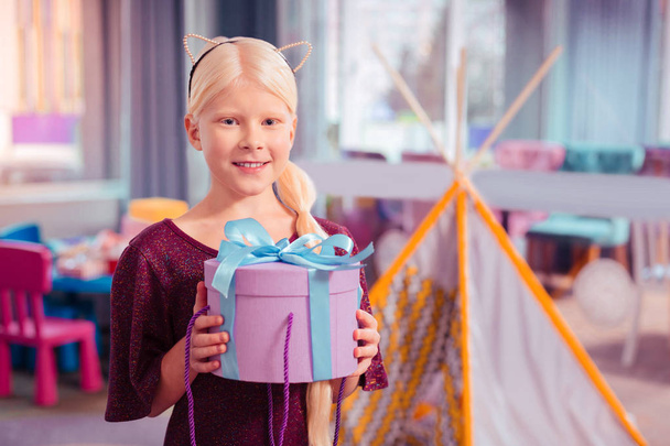 Positive delighted blonde girl holding box with present - Zdjęcie, obraz