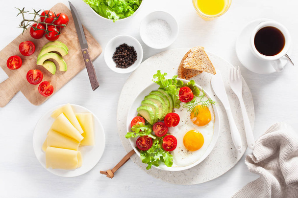 healthy breakfast flat lay. fried eggs, avocado, tomato, toasts and coffee - Photo, Image