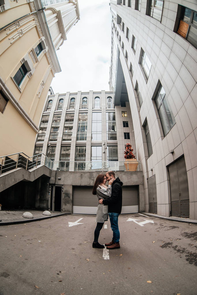 Loving couple hugging and standing between high buildings - Fotoğraf, Görsel