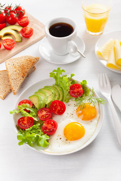 здоровый завтрак с яичницей, авокадо, помидорами, тостами и кофе
 - Фото, изображение