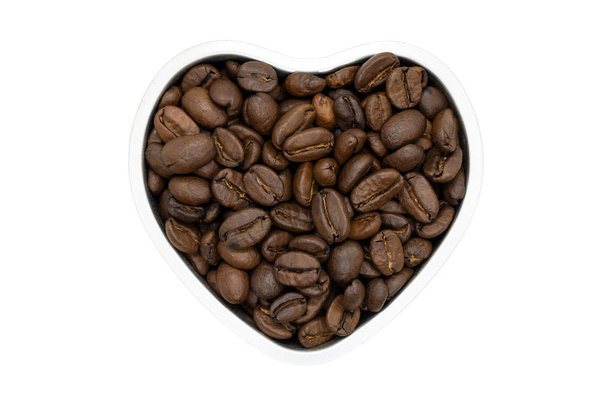Granos de café tostados, en forma de corazón, de cerca, aislados. Deliciosos granos de café de arábica india cruda
. - Foto, imagen