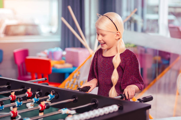 Positive delighted child standing near table game - Valokuva, kuva