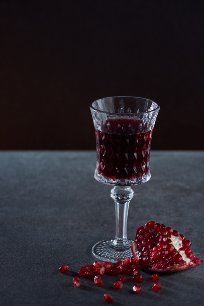 Studio shot of vintage wineglass with garnet on dark background - Zdjęcie, obraz