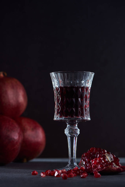 Studio shot of wineglass and ripe garnets - Фото, изображение