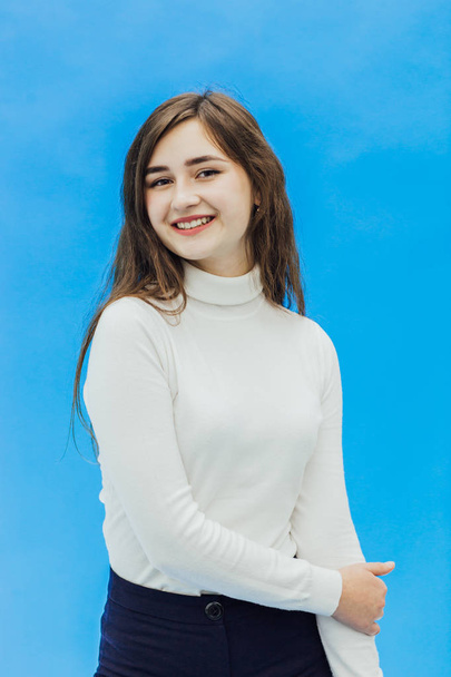 A girl on a blue background. A girl on a blue background with a smile - Foto, Imagen