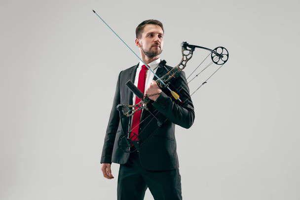 Businessman aiming at target with bow and arrow, isolated on white background - Foto, immagini