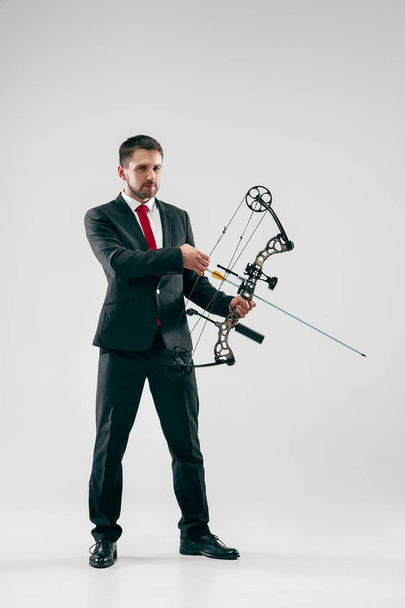 Businessman aiming at target with bow and arrow, isolated on white background - Фото, зображення
