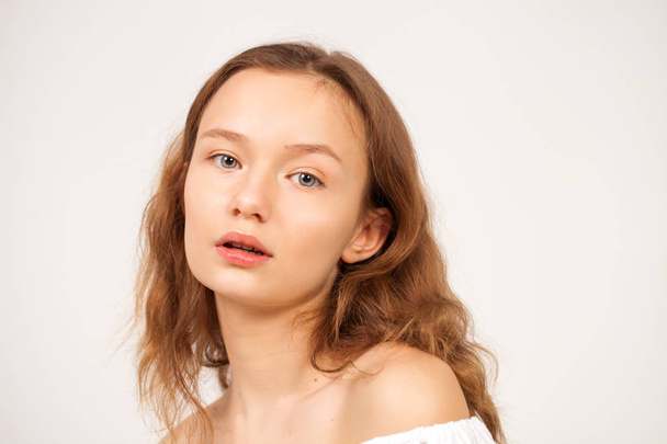 Portrait of a young teen girl close-up without makeup, isolated on red background - Foto, afbeelding