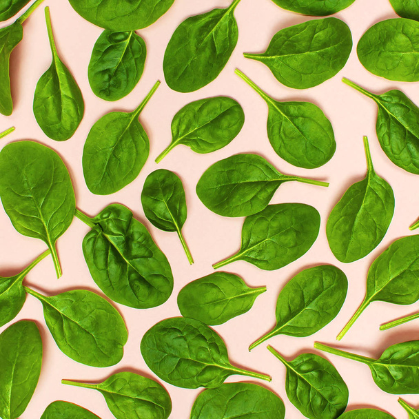 Padrão de folhas de espinafre verde fresco no fundo rosa Flat lay vista superior. Conceito de comida criativa. Ingrediente para salada. Design de padrão vegetal. Estilo de vida saudável
 - Foto, Imagem