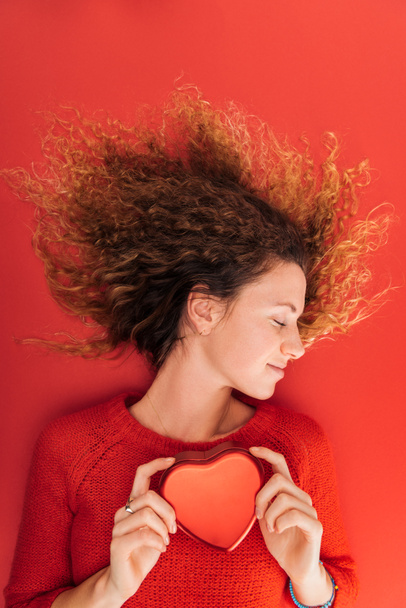 gyönyörű lány, gazdaság, elszigetelt piros, Szent Valentin-nap fogalom szív szimbólum felülnézet - Fotó, kép