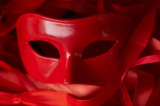 Karneval rote Maske für den Urlaub mit Bändern auf dunklem Hintergrund  - Foto, Bild