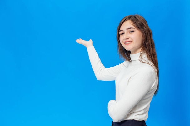 Young beautiful girl isolated on blue background - Foto, immagini