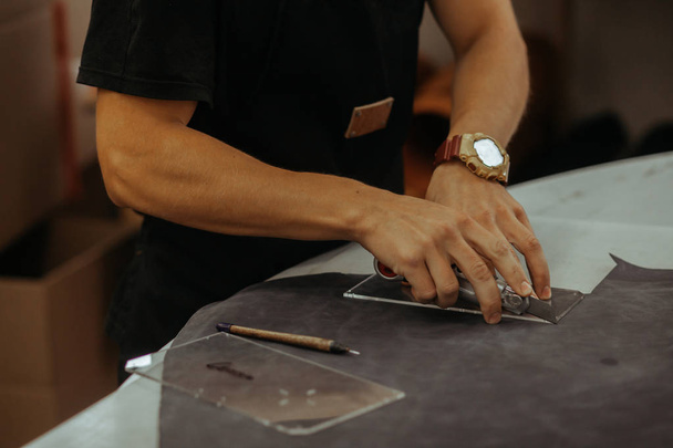 Close up of an artisan working with leather in his laboratory using tools. Handmade concept. - Foto, Imagen