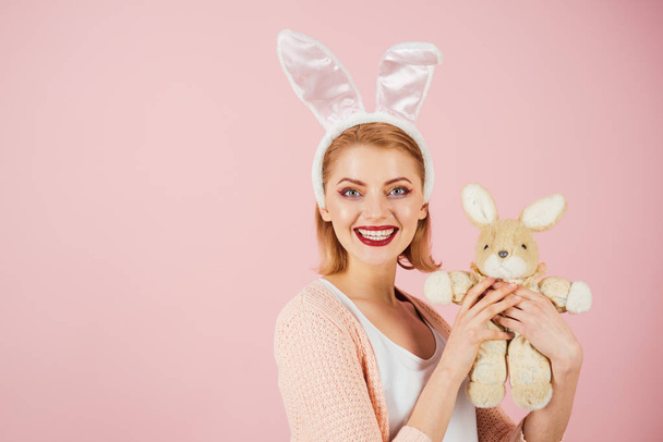 happy woman in bunny ears with toy. Woman in rabbit bunny ears. Happy easter. Spring holiday. Girl with hare toy. Egg hunt. Easter eggs as traditional food. copy space. Preparation to Easter - Фото, зображення