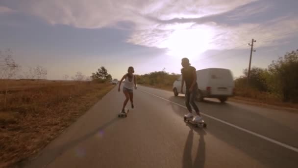 zwei junge Frauen in coolen Outfits beim Rennen mit Longboards - Filmmaterial, Video