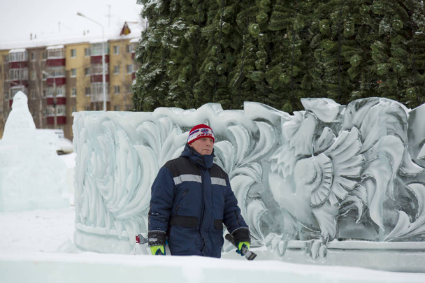 Ritratto di un lavoratore in un cantiere di montaggio di una città di ghiaccio in tuta invernale
 - Foto, immagini