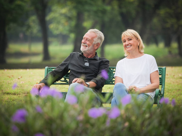 Two happy seniors retirement Man and woman are sitting and talking in park - Фото, зображення