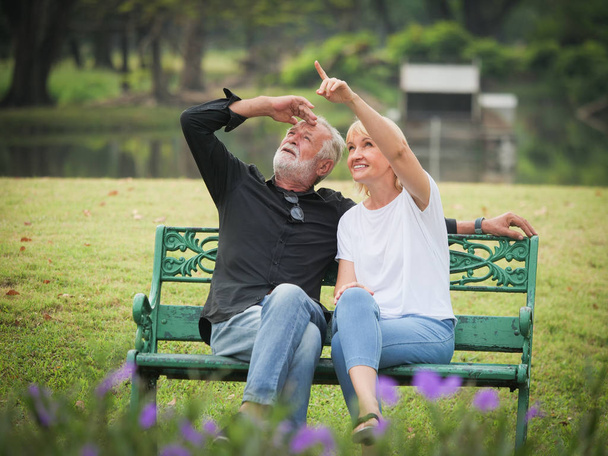 Two happy seniors retirement Man and woman are sitting and talking in park - Foto, Imagem
