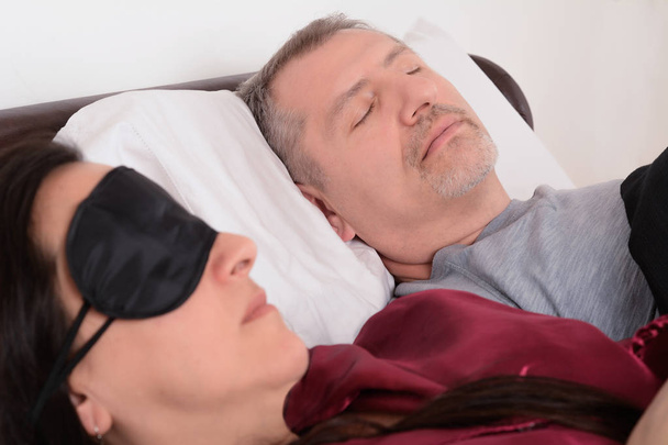 Middle age couple in sleeping together. Relationship concept. Indoors - Photo, Image