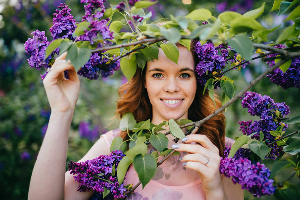portrait of beautiful tender woman in summer blooming lilac garden - Fotó, kép