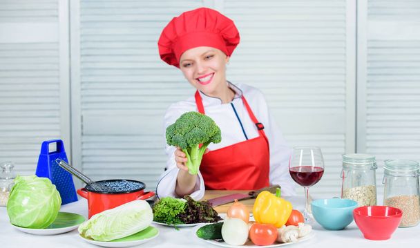 Raw food diet. Broccoli nutrition value. Woman professional chef hold raw broccoli vegetable. Free healthy vegetarian and vegan recipes. Turn broccoli into favorite ingredient. How to cook broccoli - Photo, Image