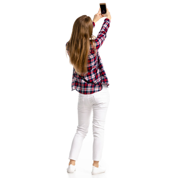 Женщина в белых джинсах и рубашке делает селфи-смартфон
 - Фото, изображение