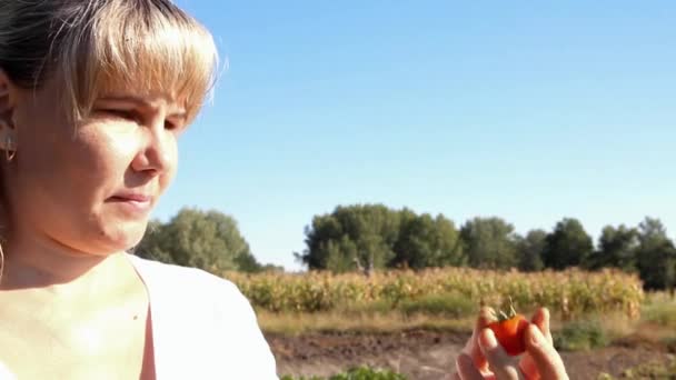 egy kis paradicsom és mosolyog néz női farmer - Felvétel, videó