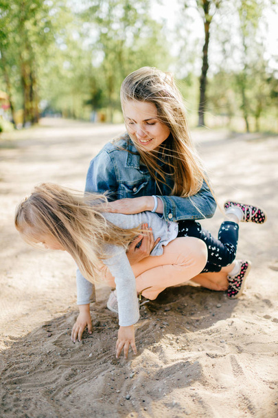 young happy mother and little daughter in park - Photo, Image