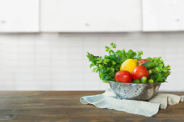 Blurred background. Modern kitchen with fresh vegetables on wooden tabletop, space for you and display products. - Фото, изображение