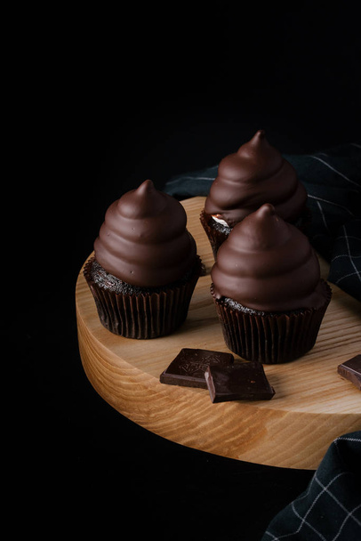 Deliciosos cupcakes de chocolate na mesa escura
 - Foto, Imagem
