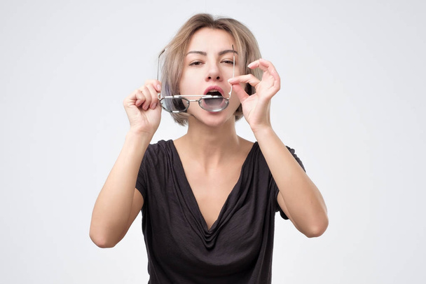 Женщина вытирает очки, очищая их от пыли
. - Фото, изображение