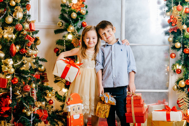 adorable kids with gifts in decorated christmas and new year studio - Foto, Bild