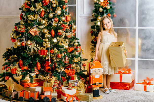 linda chica con regalos en la habitación decorada de Navidad
 - Foto, imagen