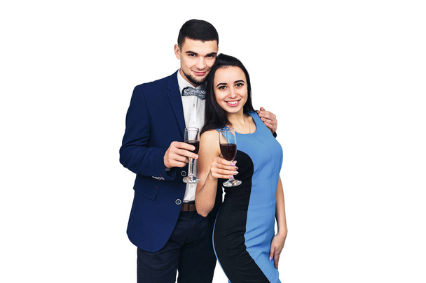 young happy stylish couple in blue clothes posing with glasses of wine - 写真・画像