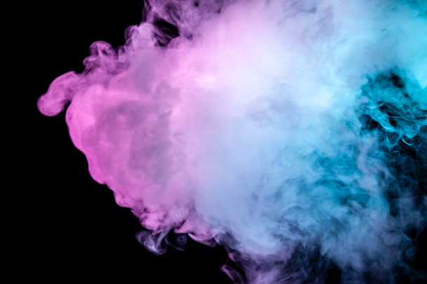 Multicolore, fumo denso, illuminato da una luce colorata in blu, viola e rosa su uno sfondo nero scuro isolato, saldato con mazze e riccioli, sorto da un vapore di vaporizzatore. Soffia vento
 - Foto, immagini