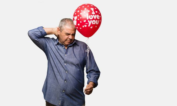 Middle aged man celebrating valentines day suffering neck pain - Photo, Image